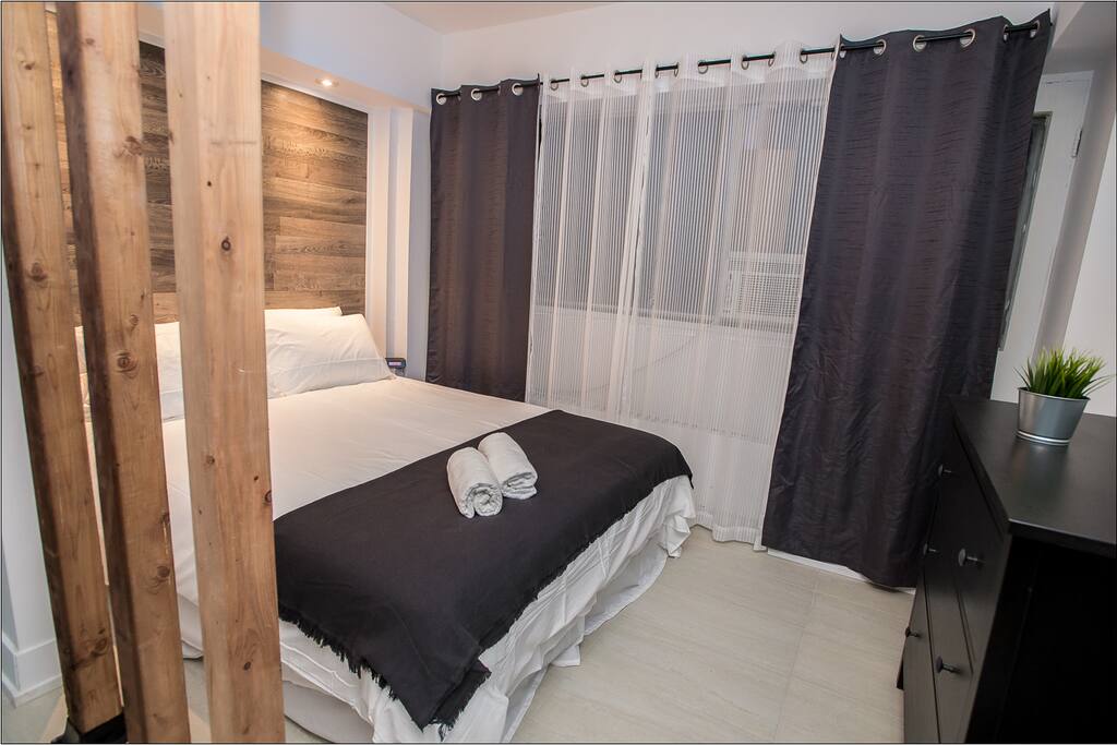 Bedroom with a wall to wall window an A/C unit and heater.