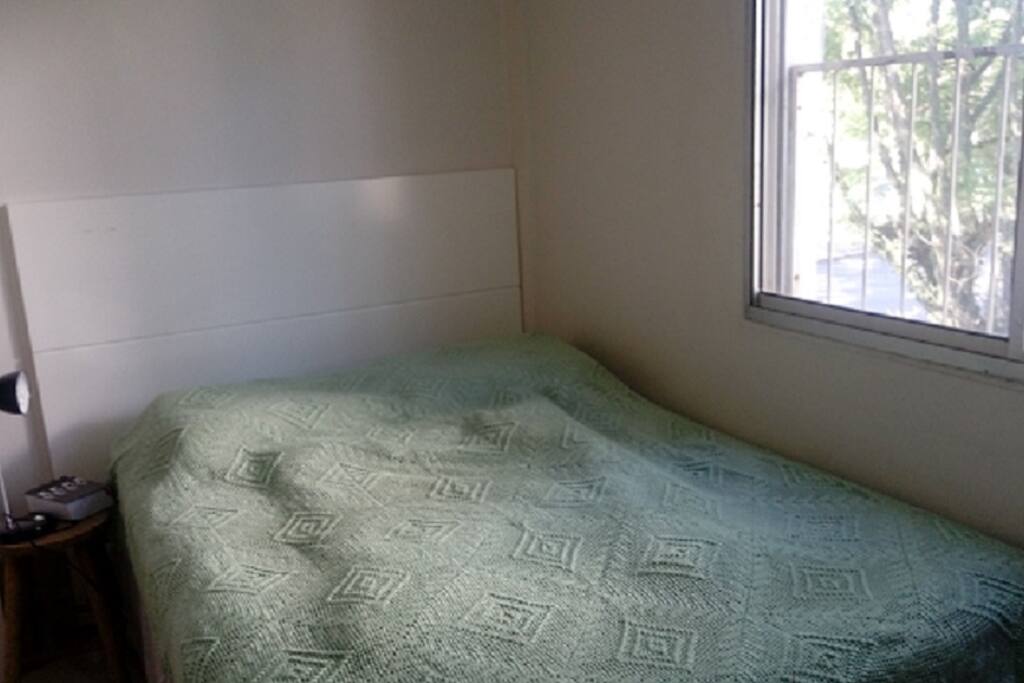 quarto com cama de casal ensolarado