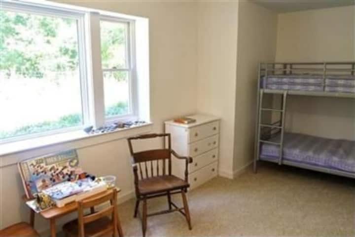 Grote slaapkamer met een stapelbed en eenpersoonsbed