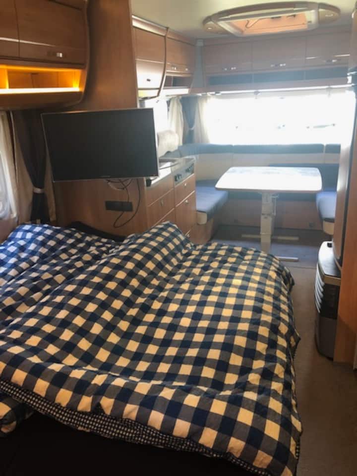 Mwonekano wa runinga na eneo la kuketi kutoka kwenye kitanda cha watu wawili.