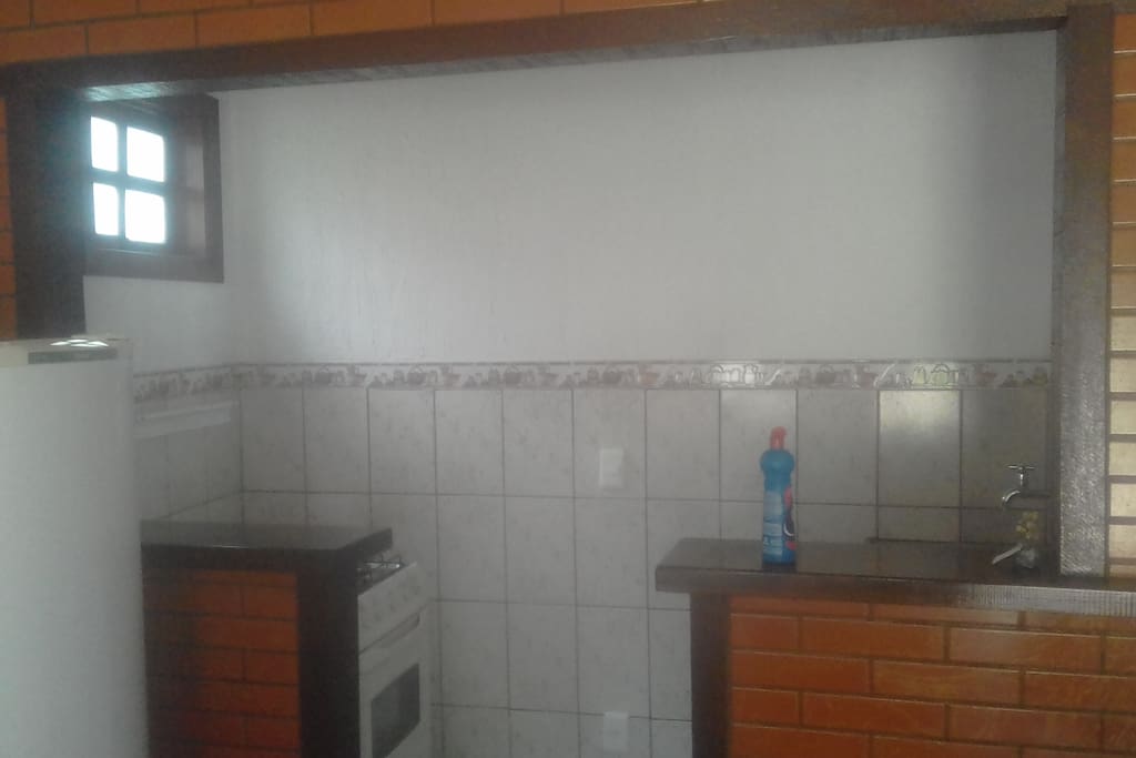 cozinha americana, fogão, geladeira e pia.