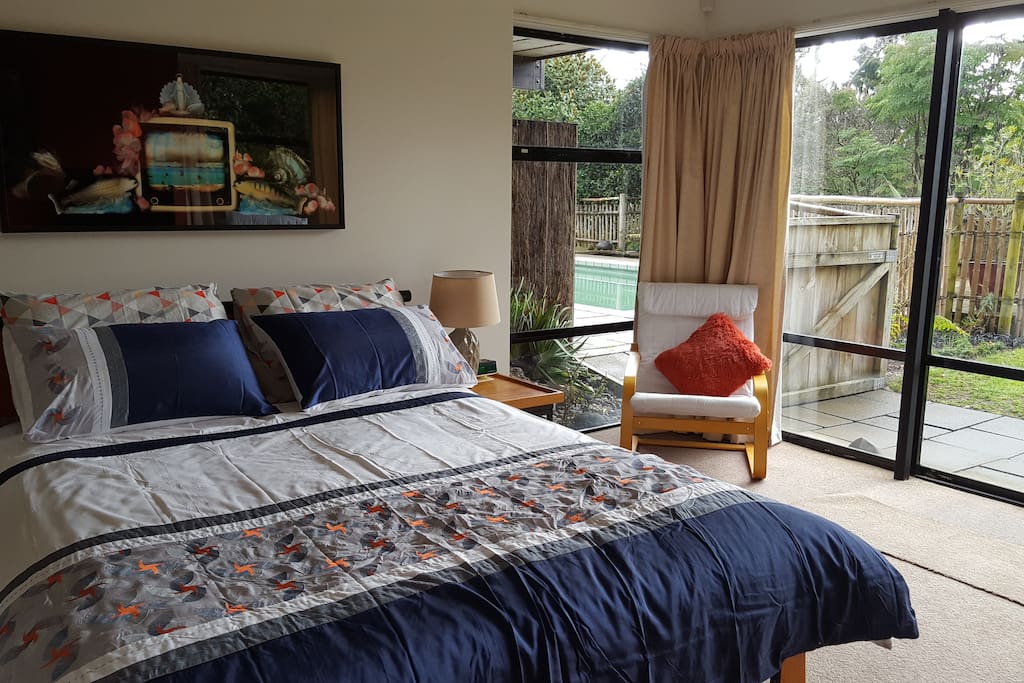 Queen sized bed looking out to the Whanganui River. Private patio area and access to swimming pool.