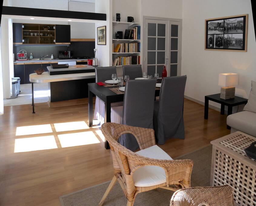 Salon, coin repas et cuisine en fond