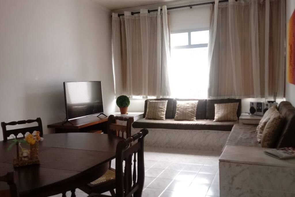 Sala com: Smart Tv 43", 2 sofás-camas, ventilador de teto, mesa com 6 lugares.