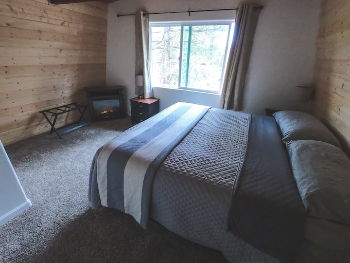 Dhomë në agim me krevat dopio "king" dhe oxhak/ngrohës elektrik.