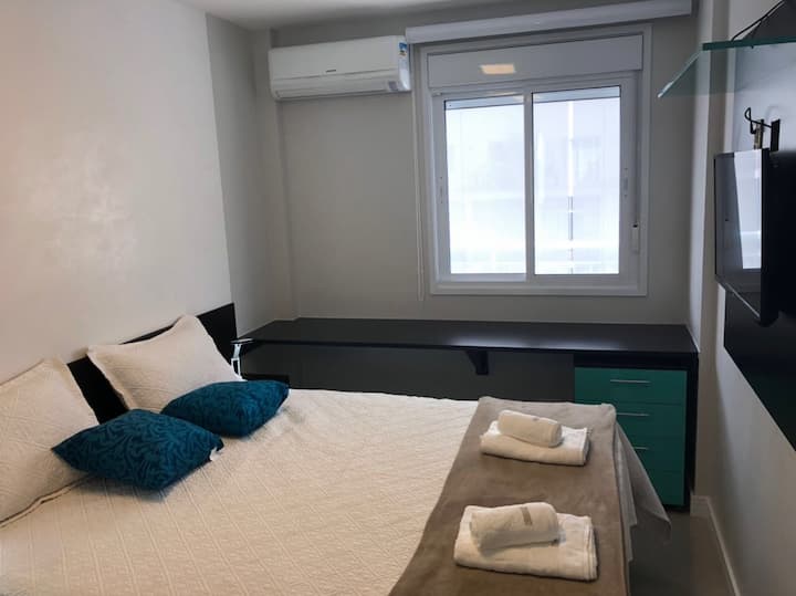 Mesa de computadora, aire acondicionado cerca de la ventana