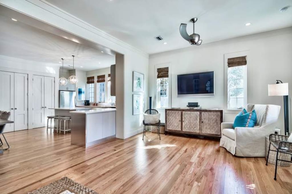The great room has hardwood flooring, recessed lighting, and access to the covered back patio