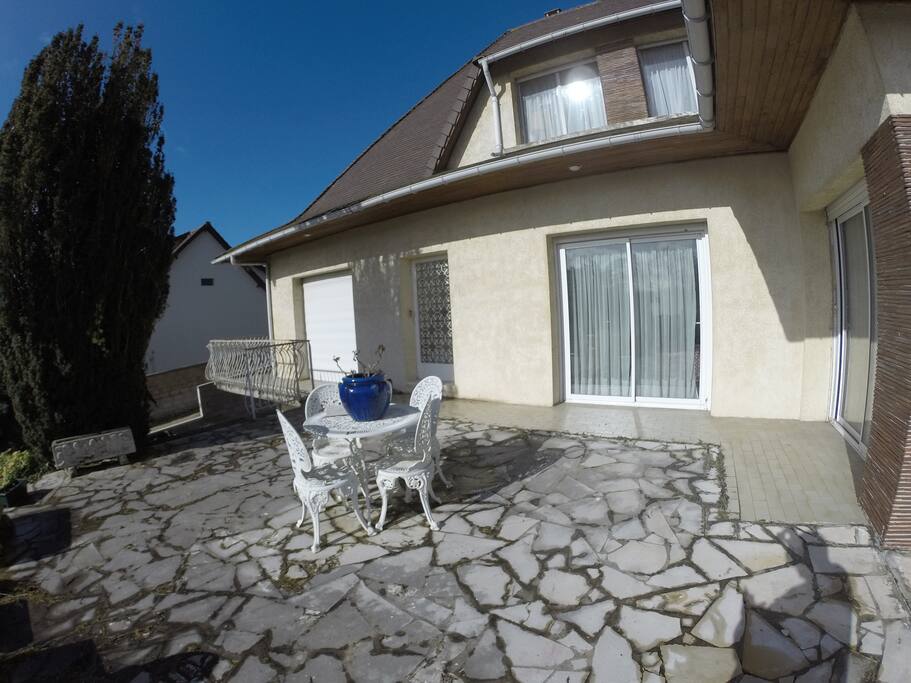 Exposition sud donnant sur une terrasse et un jardin paysagé