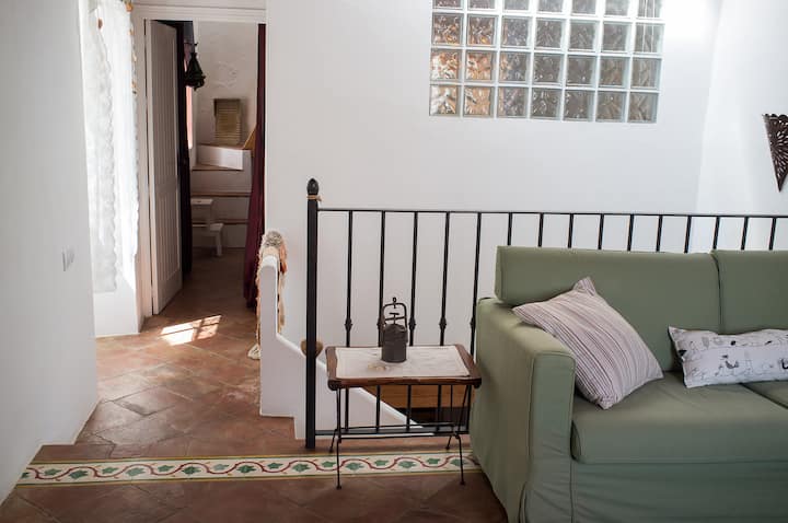 Bovenverdieping - Open kamer met slaapkamer 2 waar de woonkamer en tv zich bevinden. Vanuit dat gebied is er ook toegang tot de badkamer en de hoofdslaapkamer