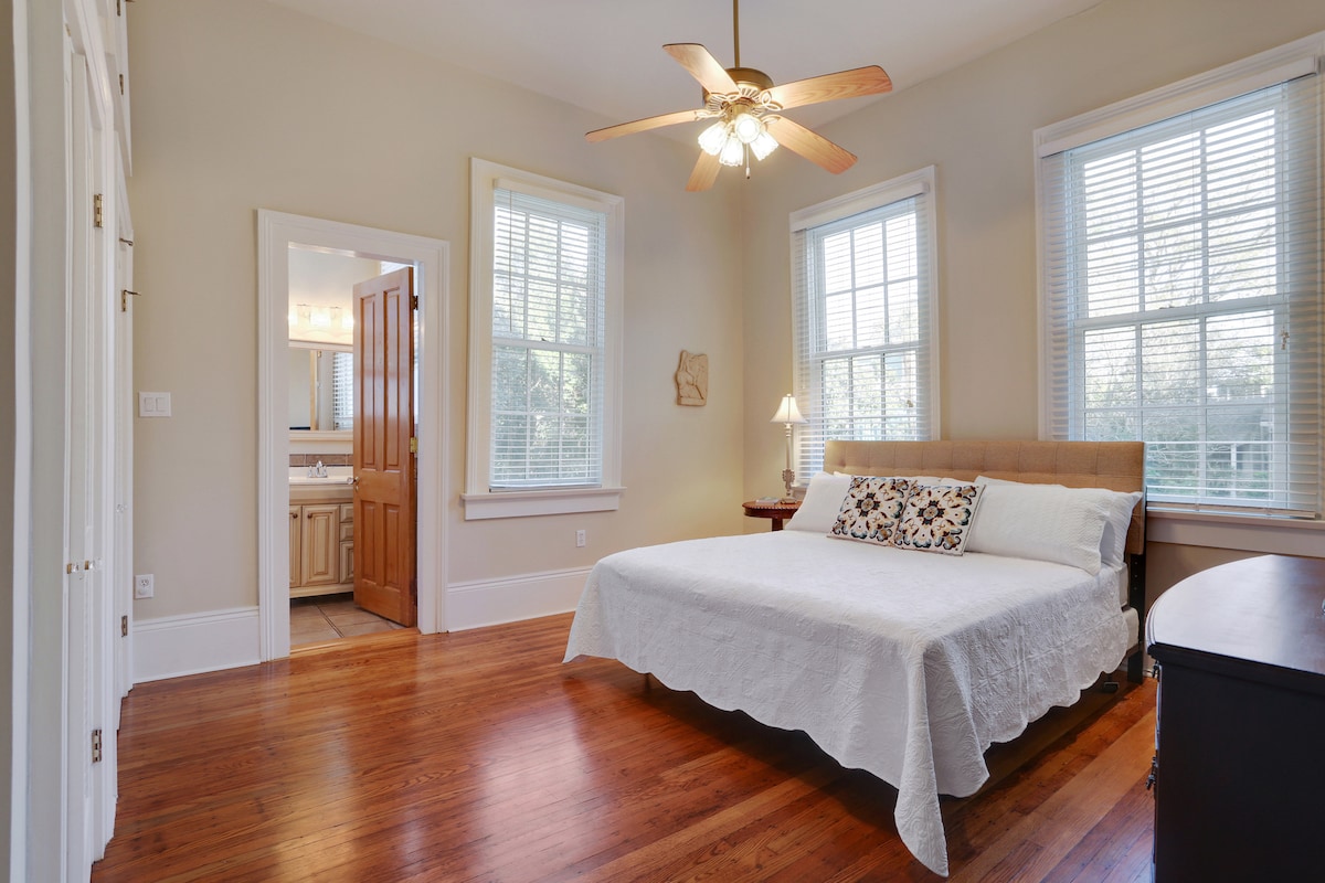 Главна спалня тип „суперголямо двойно легло“ с баня в апартамент, телевизор с плосък екран и голям гардероб.