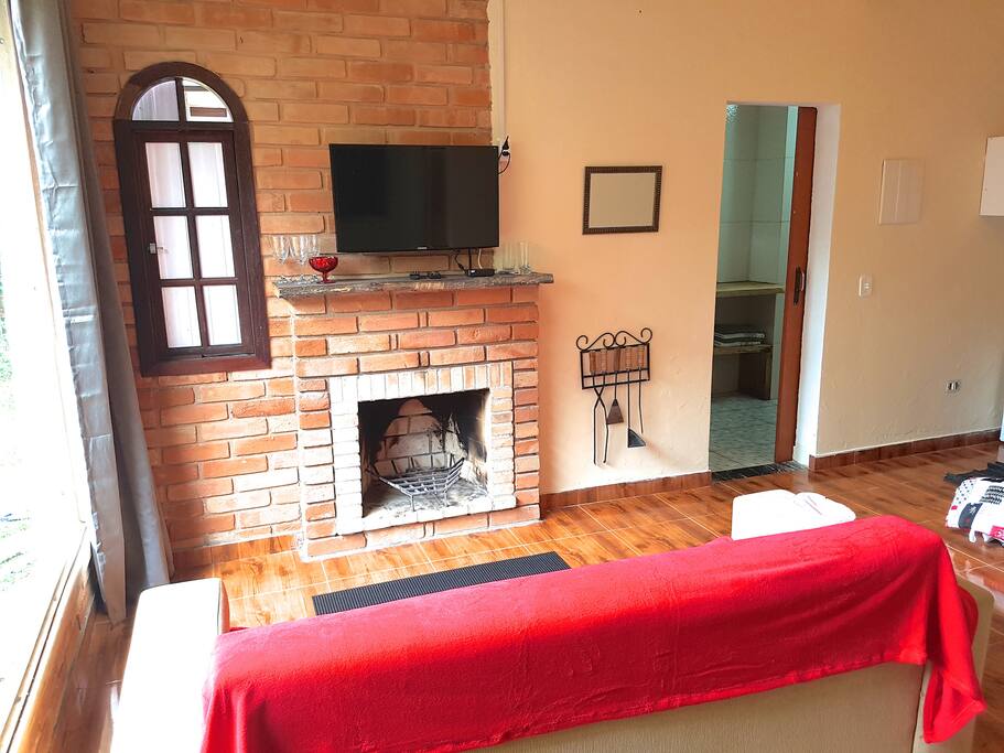 Sala com lareira, TV LCD, sofá e uma cama de casal ou duas de solteiro, frigobar e microondas