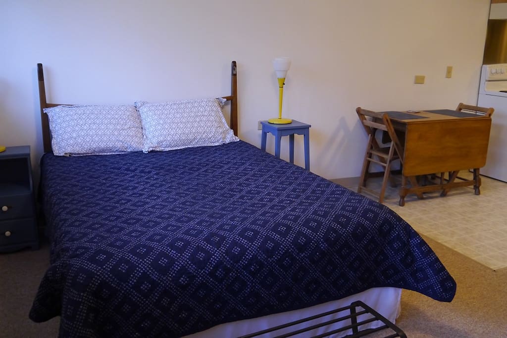A small dining table is situated between the sleeping area and kitchen.