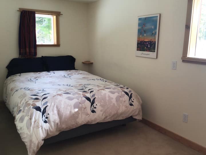 This comfortable Queen bed is in a private area beside the bathroom.
