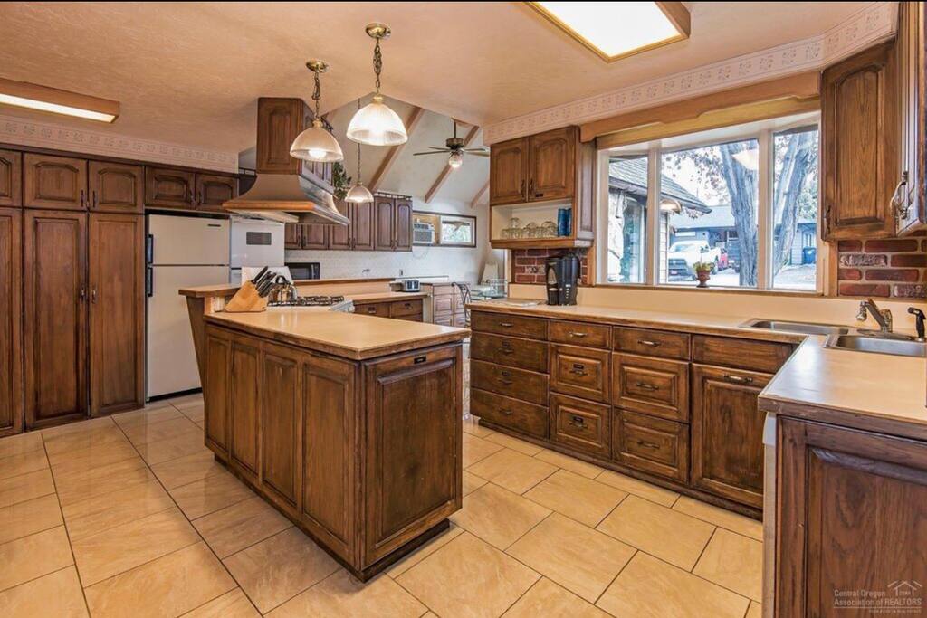 Large kitchen equipped with 3 ovens, 2 refrigerators and lays of large pans for groups