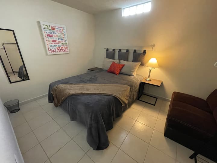 Prva soba s bračnim krevetom i foteljom te stalkom za vješanje odjeće 