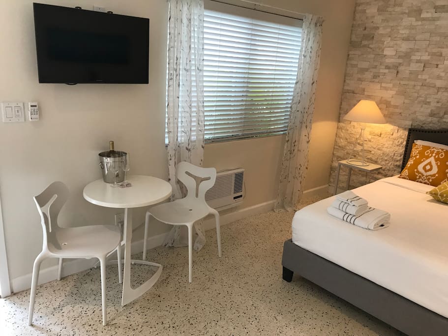 Tv with HBO channel, cute white table with chairs and welcome wine