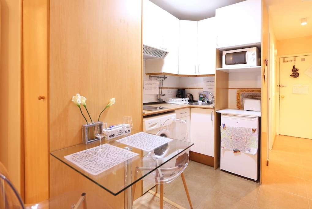 Kitchen with dinning table, washing machine, stove, microwave