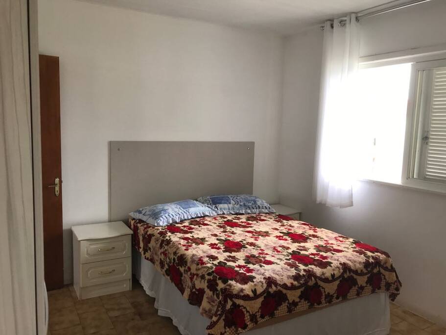 Suíte com cama de casal, armário, banheiro privativo, ventilador e TV digital