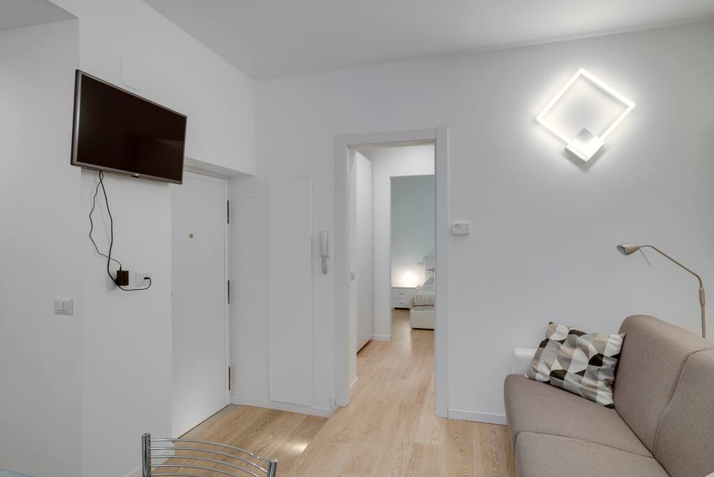 Soggiorno con parquet e TV a parete