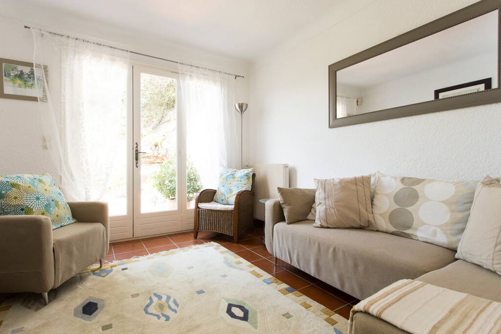 Living room with TV , DVD player , fan and double french doors to terrace.