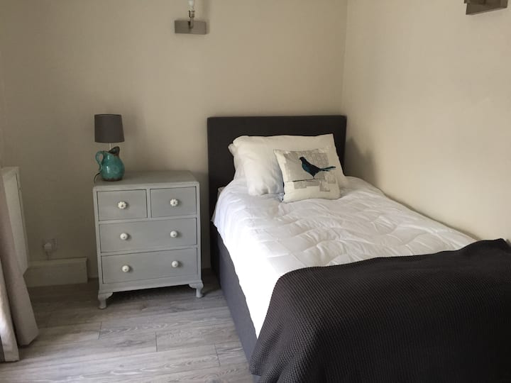 Dhomë e këndshme teke në katin përdhes me qasje të lehtë në tualetin e katit të poshtëm.