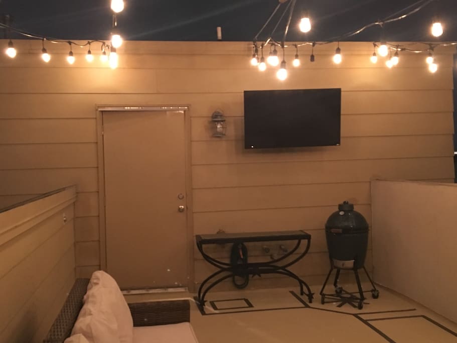 Tv and grill located on rooftop patio, perfect for watching the big game!