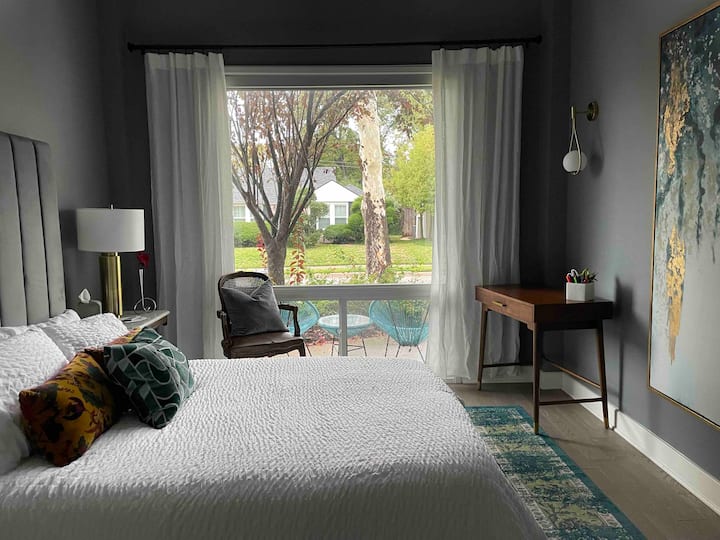 Habitación delantera azul con cama queen, escritorio, televisión, armario, sombra oscurecedora y una vista preciosa del barrio.  