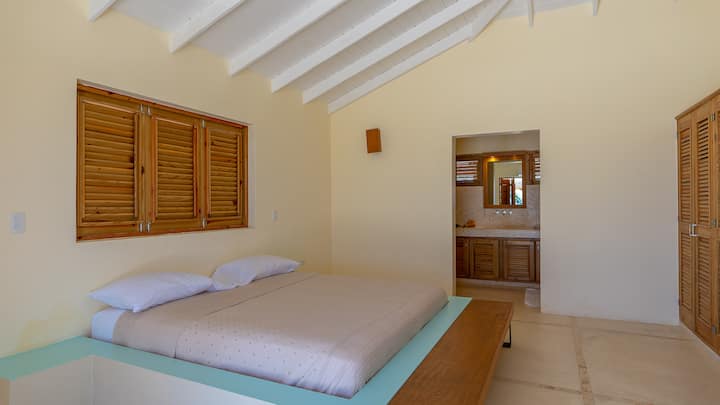 Bungalow next to villa: LEFT bedroom with king bed, ac, bathroom with sink, toilet and shower.