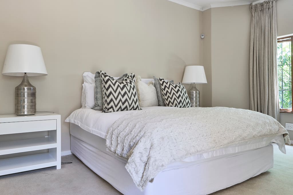 Spacious master bedroom with deluxe super king bed, large bedside tables and dressing table. The bedroom also has direct access to the garden.