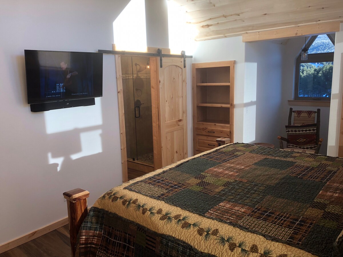 ห้องนอนมีเตียงคิงไซส์ที่สะดวกสบายและเตียงเด็กเล็กติดตั้งอยู่บนผนัง 