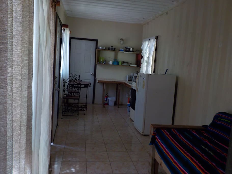 The kitchen area has fridge, stove/oven, toaster, coffee maker, table and chair set and kitchen essentials.