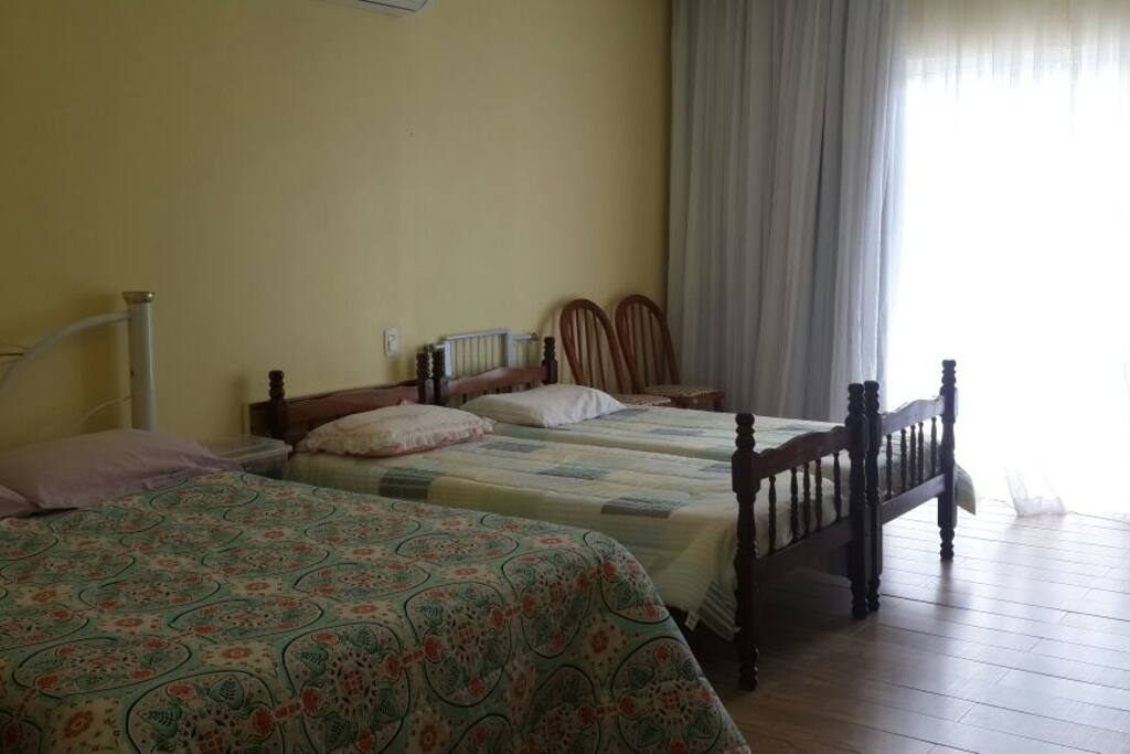 Quarto com cama de casal e 2 de solteiro. A pedido podemos tirar as de solteiro.