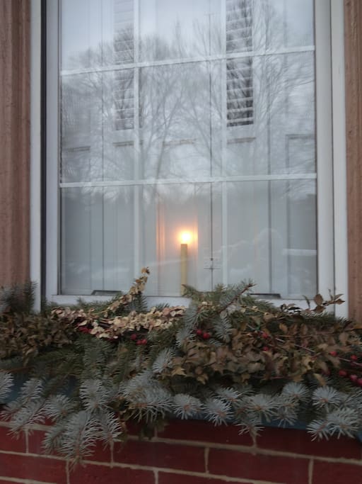 Holiday window greens and welcome candle