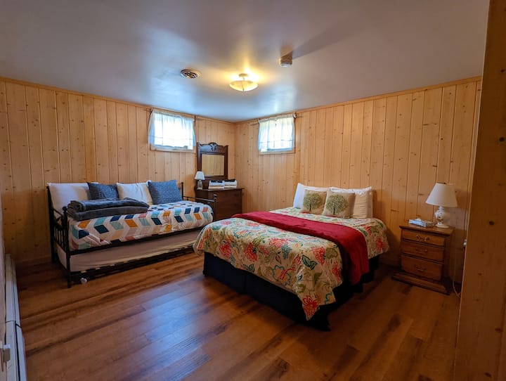 Lower level bedroom with queen bed and daybed with two twins.
