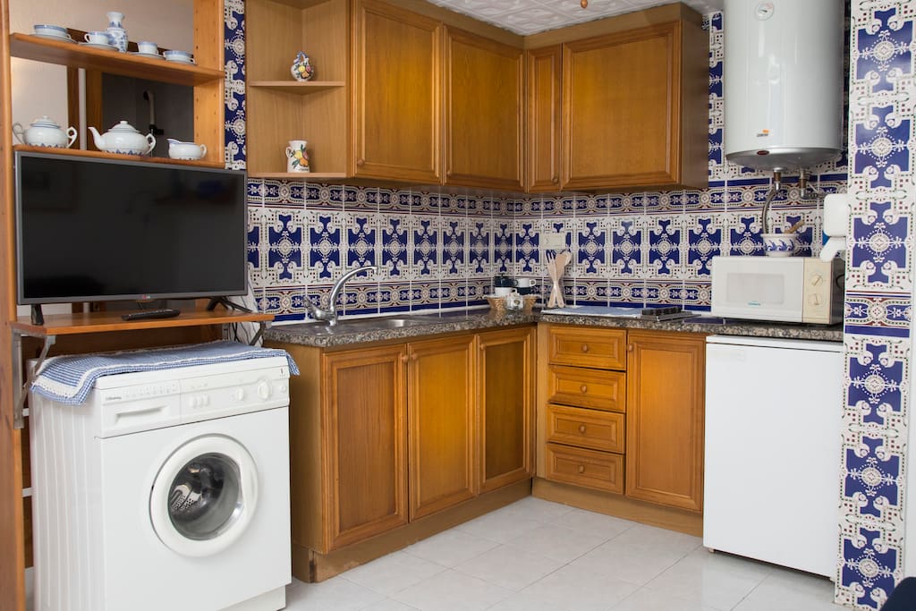 Cocina equipada con nevera, microondas y lavadora