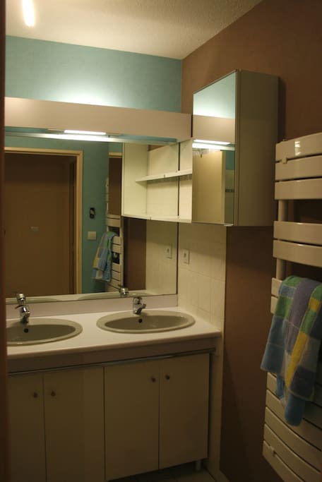 Sale de bain avec baignoire et double vasques.