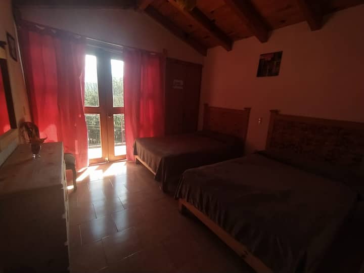Recamara gemela 1 con dos camas matrimoniales y balcón con vista al bosque