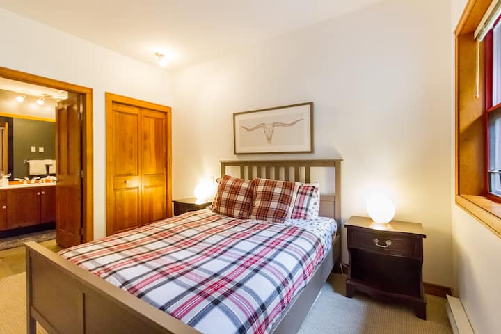 Dormitorio principal con cama de matrimonio y baño privado.