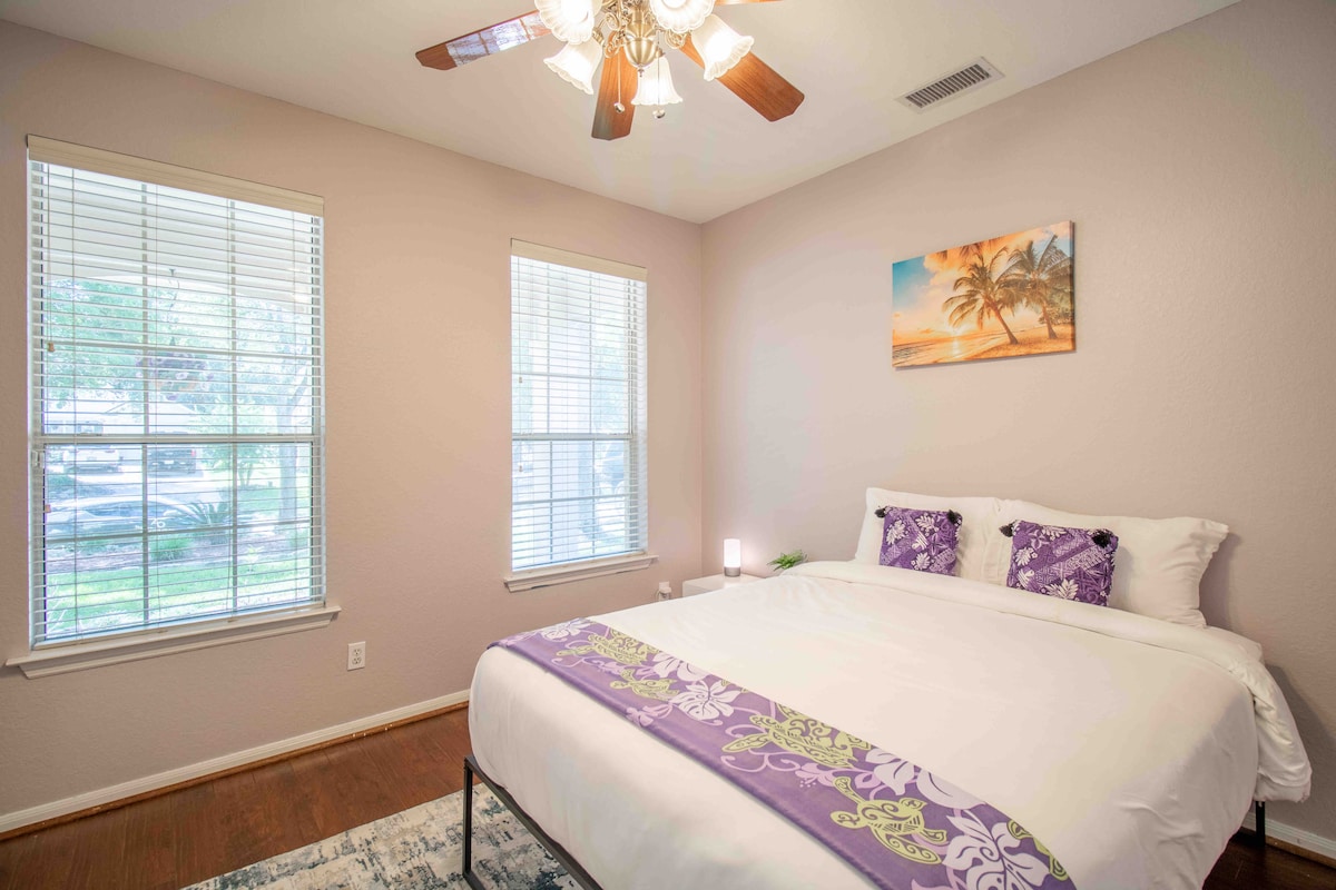 Spavaća soba 1 - bračni krevet s pogledom na dvorište i francuska vrata koja vode do tropskog dnevnog boravka. 