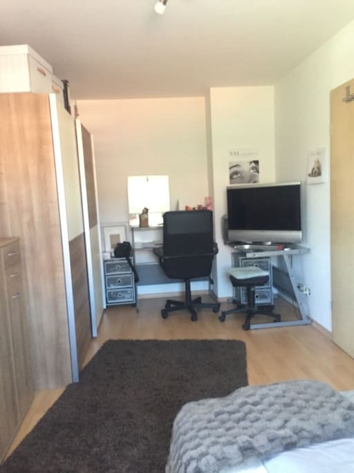 Schrank, Schreibtisch und großer Fernseher