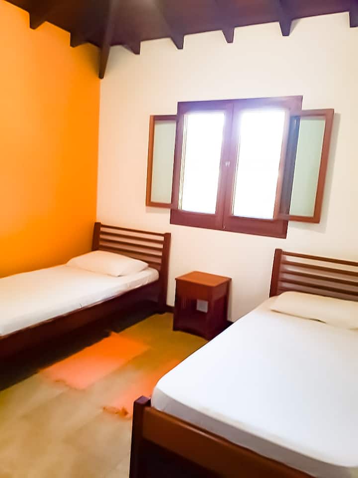 Narančasta spavaonica sa stropnim ventilatorom.