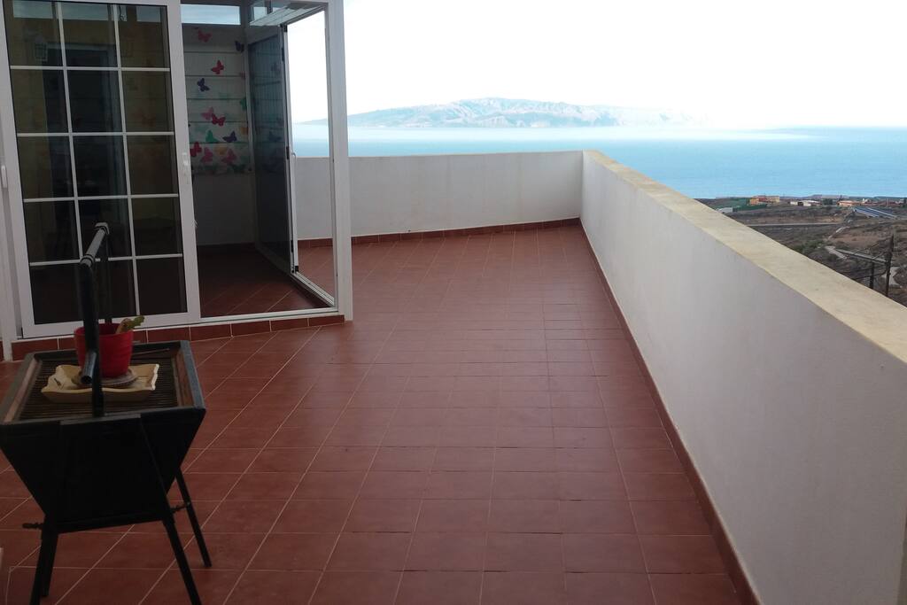 terraza con vistas al mar y a la montaña.