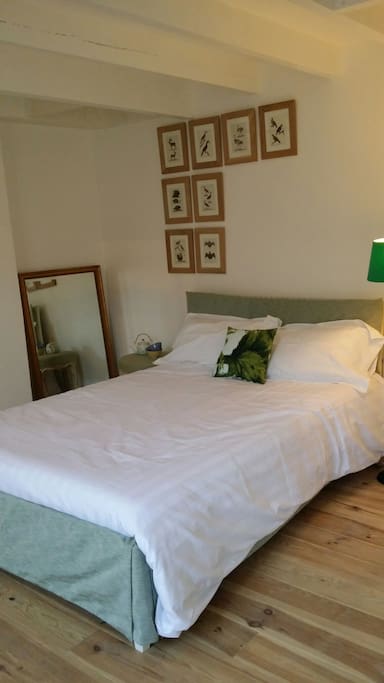 Grand lit double ambiance chaleureuse et confortable