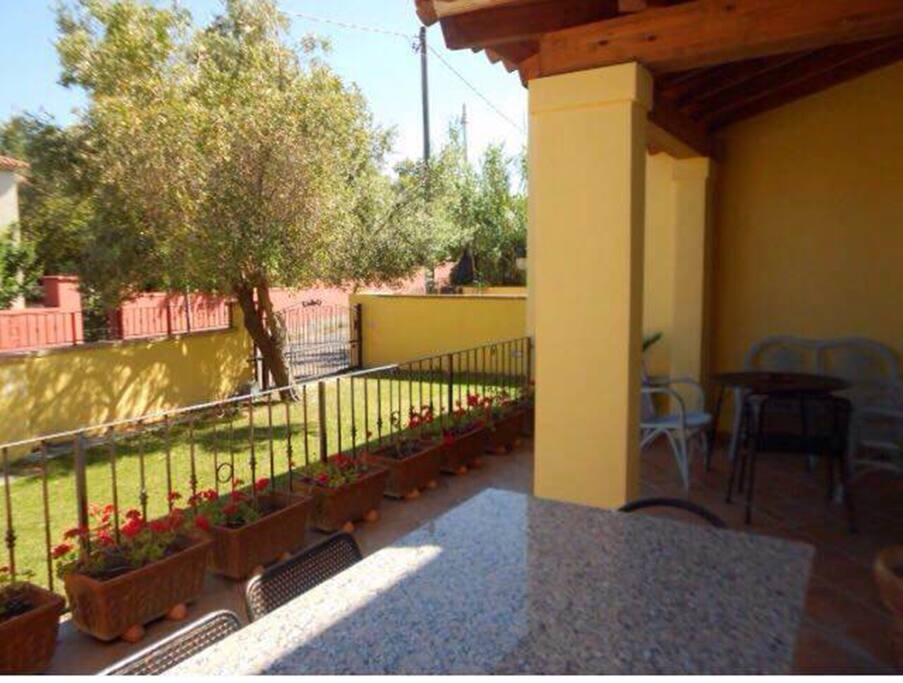 veranda con divanetto, tavolo per 4 persone e grande tavolo di marmo per cene con amici