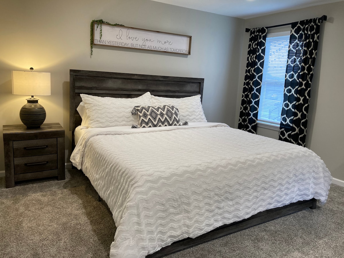 Grote slaapkamer op de eerste verdieping met een kingsize bed en dressoir