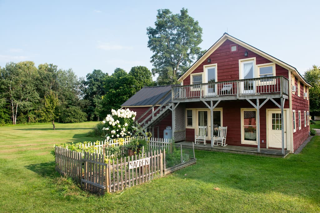 Rear of guest house with vegetable garden, small porch and balcony.
