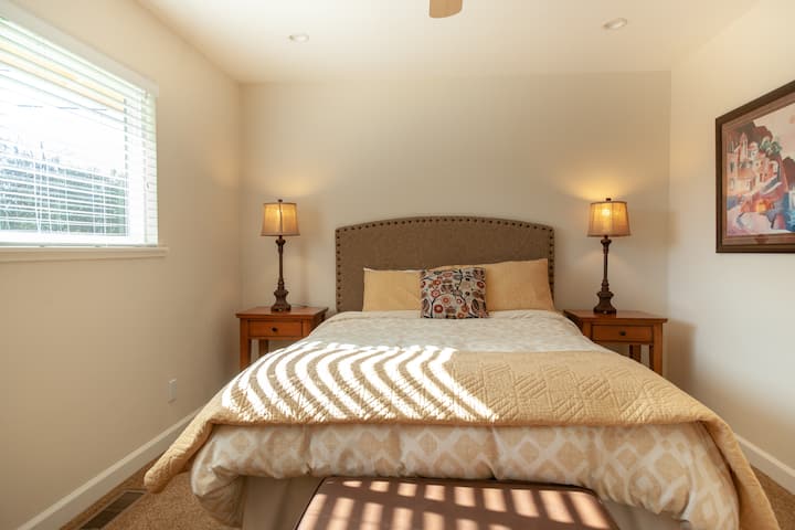 La habitación de invitados con una cama tamaño queen.   Hay una variedad de libros para leer en el armario.