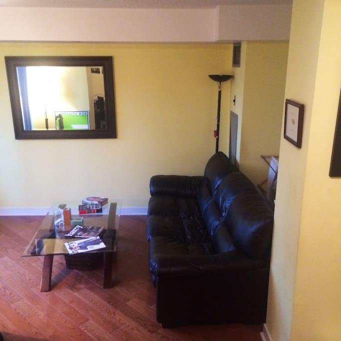 Living room with brown leather couch and solid oak flooring
