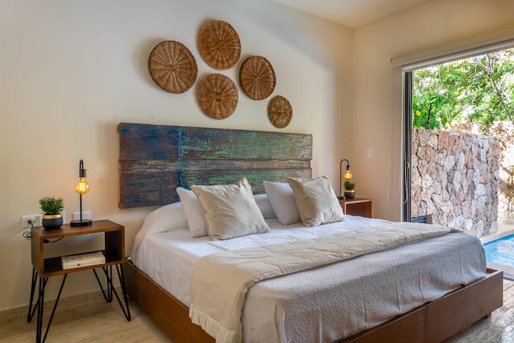 חדר שינה ראשי, עם מיטת קינג סייז, כולל ארון ומסך טלוויזיה, גישה ישירה לבריכה/ג'קוזי הפרטית, קישוטי בוהו מקומיים יפהפיים