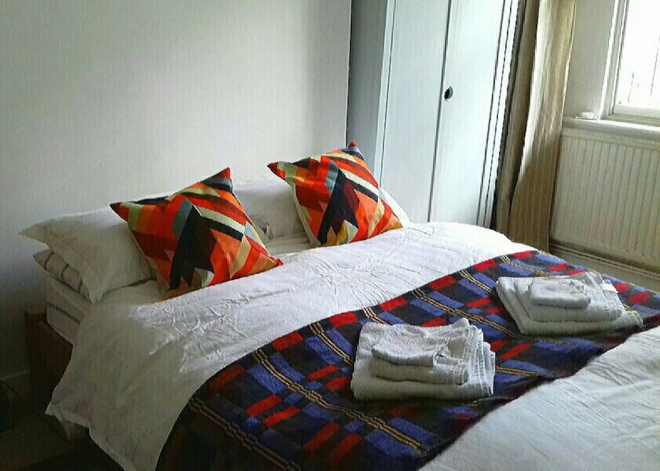 Comfortable standard double bed with cotton sheets.